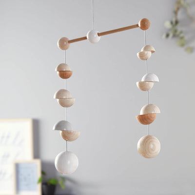 Wooden Mobile Dots featuring a mix of round and half-sphere shapes in natural and white finishes, suspended against a soft backdrop.