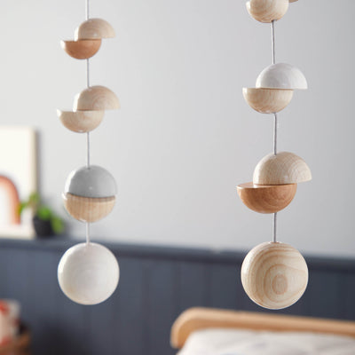 Wooden Mobile Dots hang from the ceiling, featuring alternating wooden half-spheres in light and dark colors.