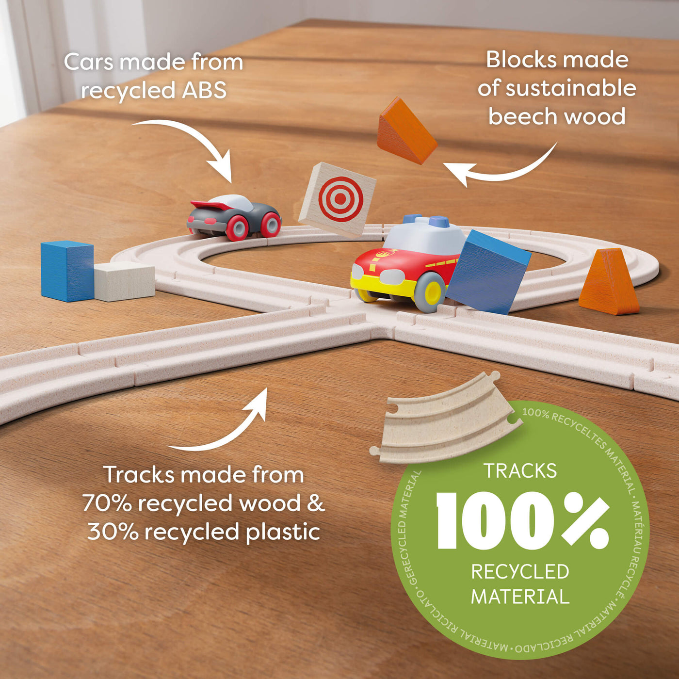 Toy car track set on a table highlighting eco-friendly materials used for cars, blocks, and tracks. with the words "Cars made from recycled ABS. Blocks made of sustainable beech wood. Tracks made from 70% recycled wood & 30% recycled plastic. Tracks 100% Recycled Material"