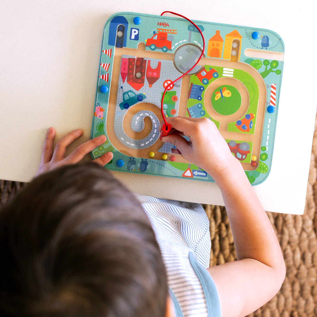 Overhead view of a child playing with HABA Magnetic Town Maze