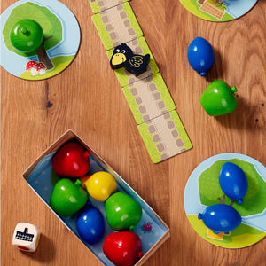Overhead view of HABA First Orchard game pieces on a wood table