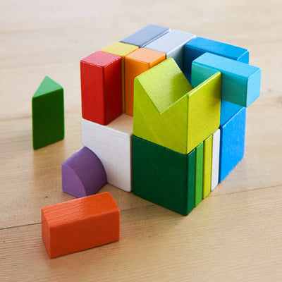 Chromatix colorful wooden blocks in various shapes assembled into a cube on a wooden surface.