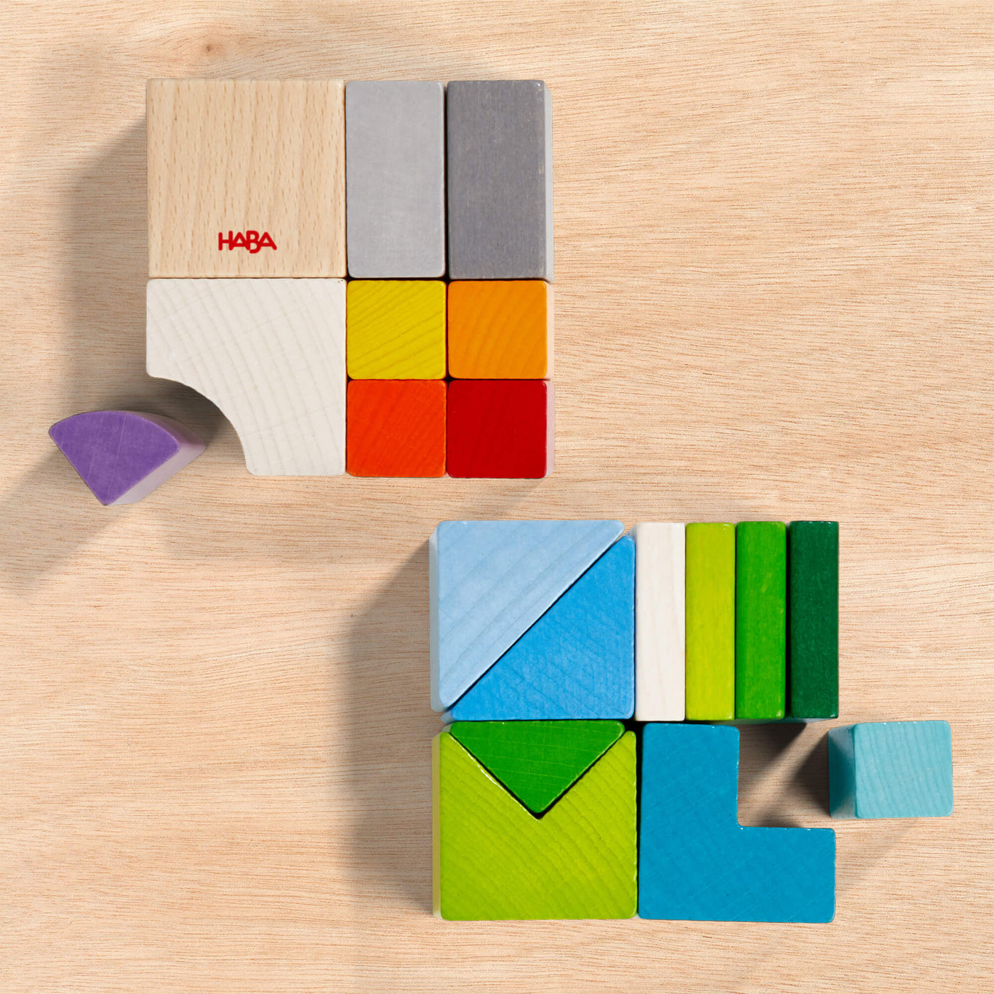 Chromatix colorful wooden blocks arranged into two squares on a light wood surface with varying sizes and shapes.