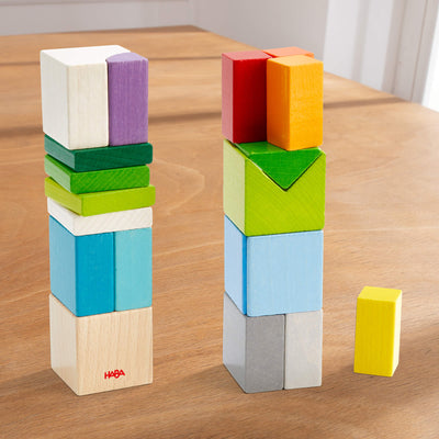 Chromatix blocks set built into two stacks of colorful wooden blocks and one separate yellow block on a wooden table.