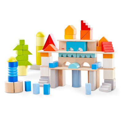 Colored Building Blocks 85 Piece Set with green, blues, red, orange, yellows, white, gray, and natural colored wooden building blocks stacked