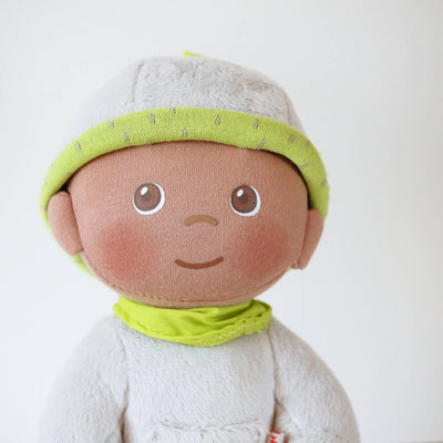 Close up of HABA Snug Up Doll Ollie's face with grey fleece body, green bandana, printed face, and grey fleece cap with green band