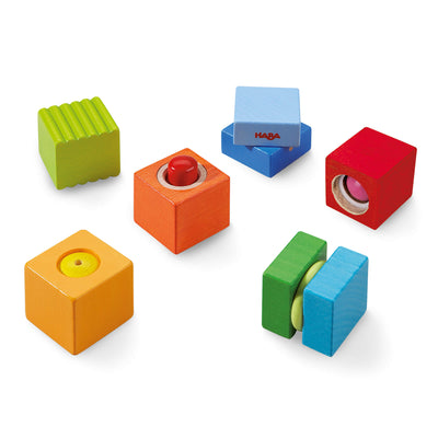 A variety of colorful wooden blocks in different shapes and sizes, featuring holes, textures, and bright colors.