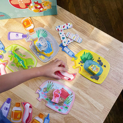 Child placing a game piece among colorful animal-themed game pieces on a wooden table.