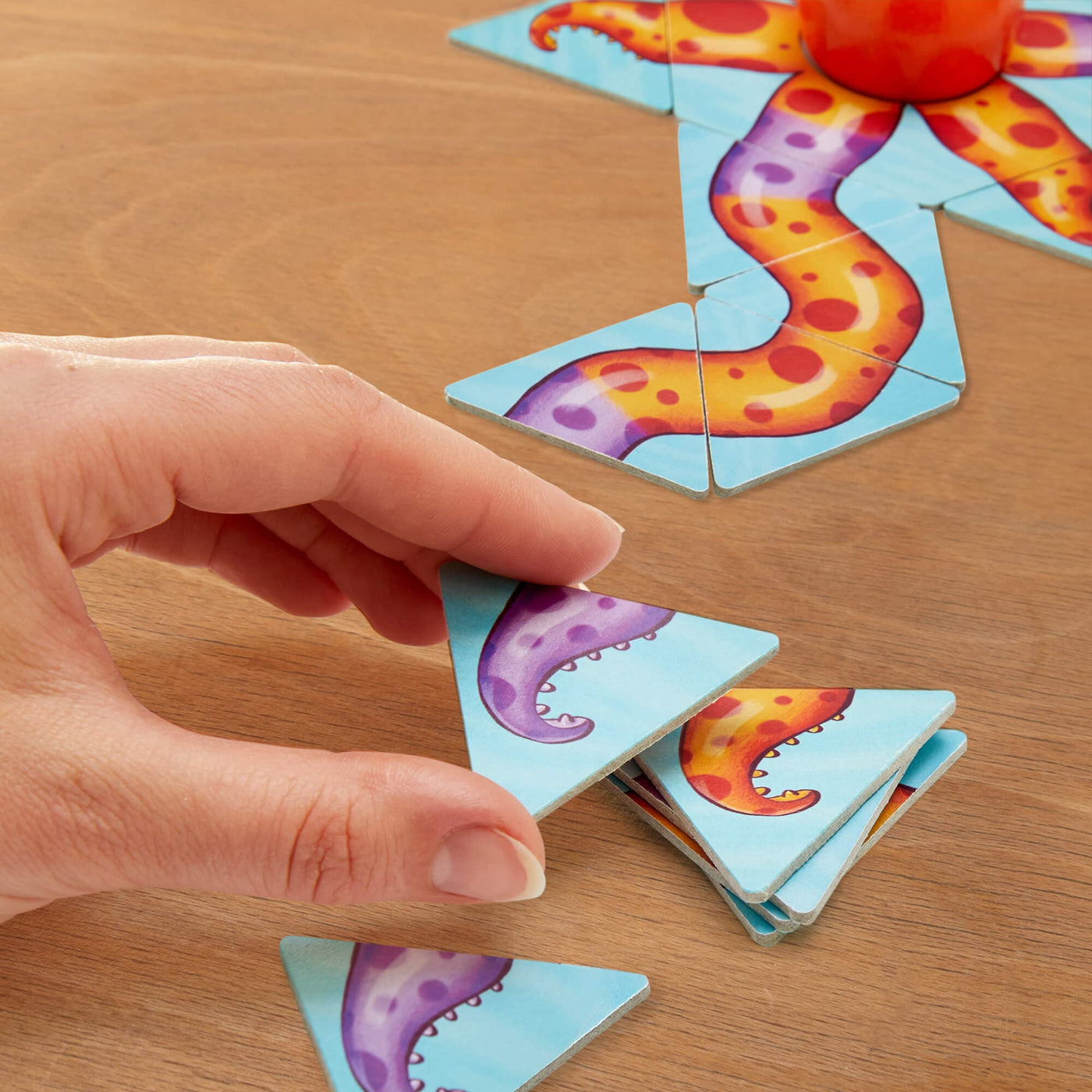 Close up of a hand holding a purple tenticle tile