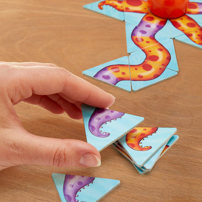 Close up of a hand holding a purple tenticle tile