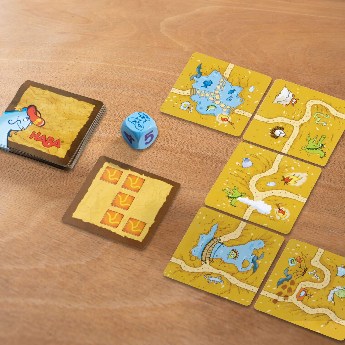 Logic Labyrinth game tile cards on a wooden table with a blue die