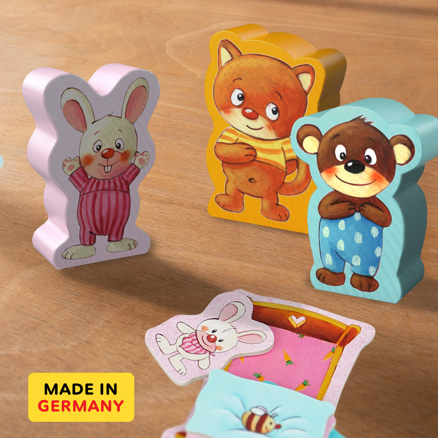 Off To Bed! colorful wooden animal pieces including a bunny, bear, and cat resting on a wooden surface next to illustrated cards. Made in Germany