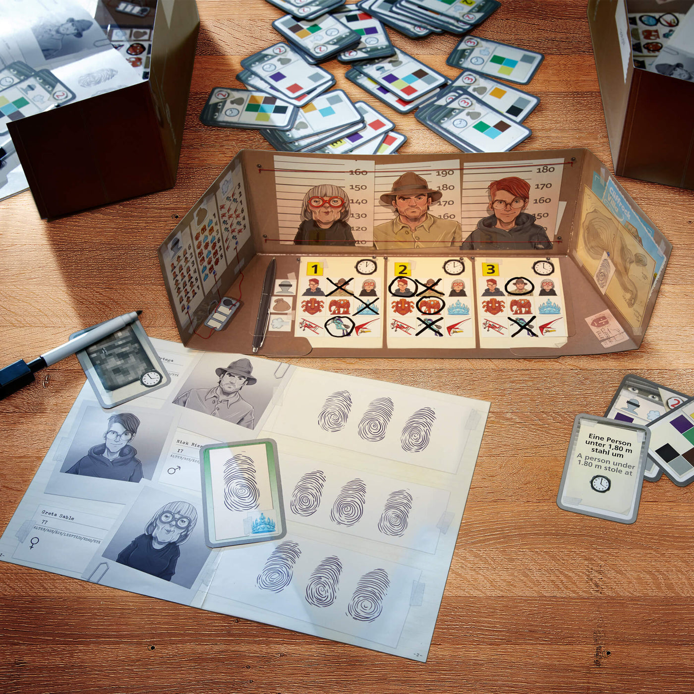 The Key: Theft at Cliffrock Villa tabletop board game setup with character illustrations, fingerprints, cards, and game pieces on a wooden surface.