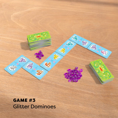 Game 3 Glitter Dominoes with purple gems on wooden table