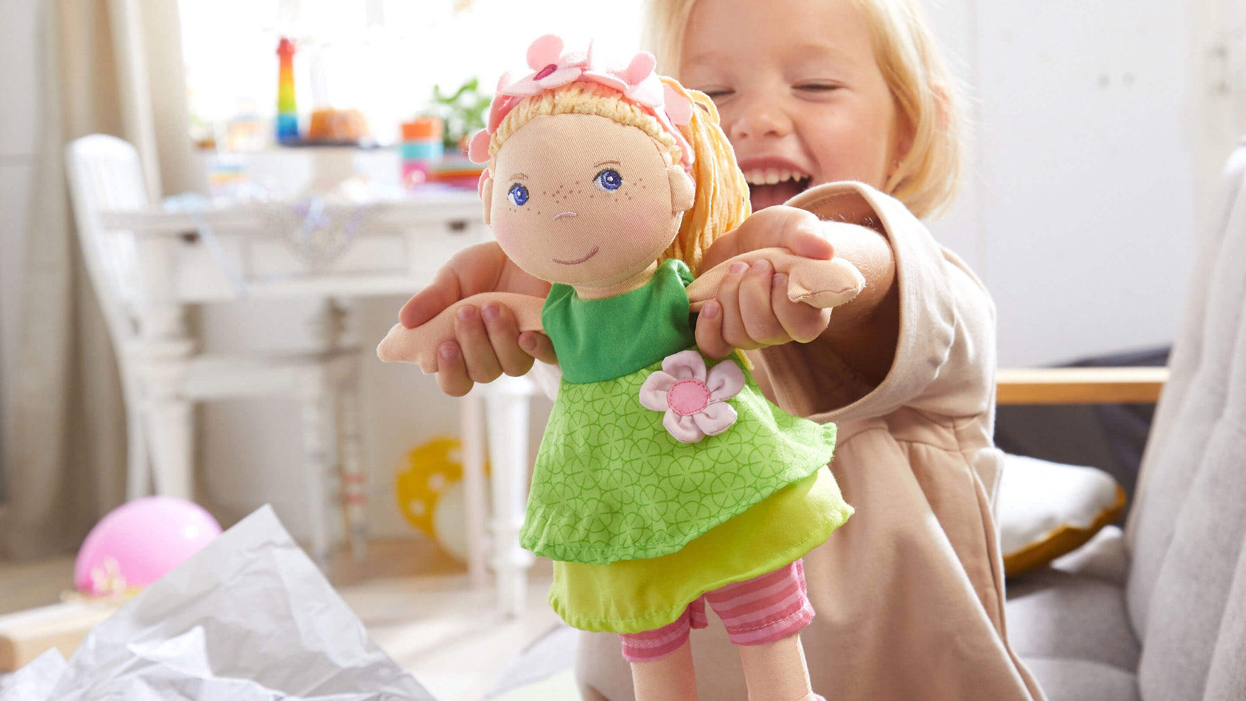 Happy girl holding up Mali doll