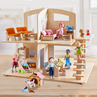 A wooden dollhouse with dolls and furniture, featuring multiple rooms and small figures engaged in various activities.